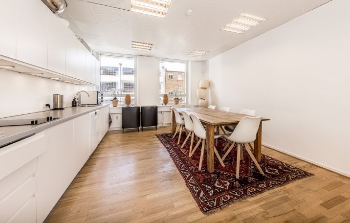 Kontorlejemål med lyst og ryddeligt køkken med lyse trægulve og moderne møbler