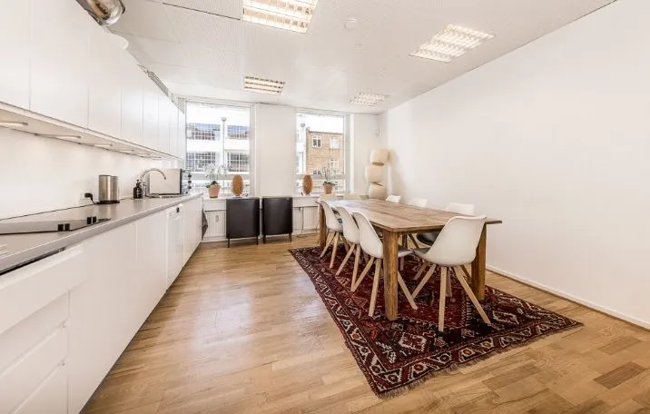 Kontorlejemål med lyst og ryddeligt køkken med lyse trægulve og moderne møbler