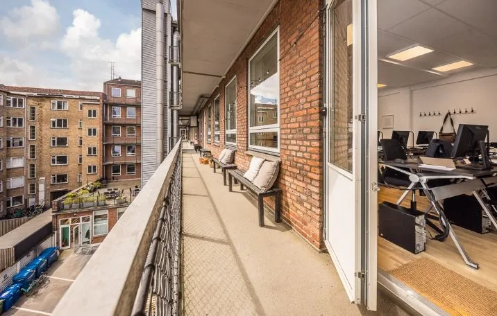 Kontor i Frederiksstaden med terrasse og udsigt over byens træer og biler på parkeringspladsen
