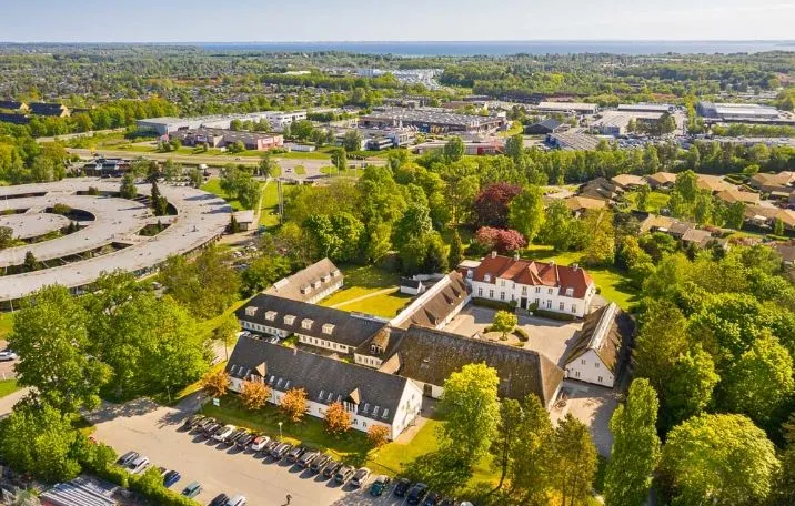 Her er et charmerende kontor på 420 m² i stueplan med en hyggelig gårdhave og mange parkerede biler på parkeringspladsen